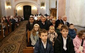 Wierni siedzą w ławach kościelnych