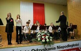 Orkiestra na scenie gra hymn Polski