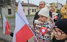 Dzieci trzymające w rękach biało-czerwone flagi