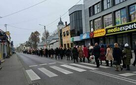 Uczestnicy obchod&oacute;w maszerują ulicą do kościoła