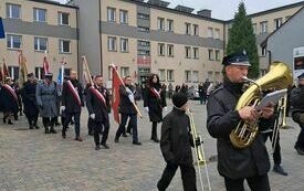 Wymarsz orkiestry i poczt&oacute;w sztandarowych sprzed Urzędu Gminy Włoszczowa do kościoła