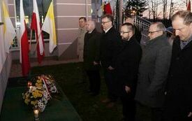 Delegacja Powiatu Włoszczowskiego składa wiązankę kwiat&oacute;w przed tablicą poświęconą Janowi Pawłowi II, kt&oacute;ra wisi na ścianie szpitala