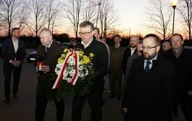 Delegacja Powiatu Włoszczowskiego składa wiązankę kwiat&oacute;w przed tablicą poświęconą Janowi Pawłowi II, kt&oacute;ra wisi na ścianie szpitala