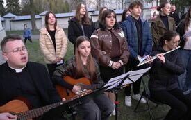 Na placu kościelnym gra i śpiewa ch&oacute;r parafialny