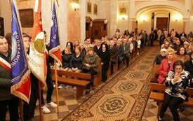 Wierni siedzą w ławkach kościelnych