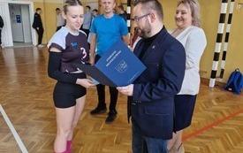 Członek Zarządu Powiatu Włoszczowskiego Rafał Pacanowski wręcza jednej z zawodniczek dyplom