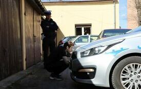 Policjant ocenia jednego z uczni&oacute;w biorących udział w konkurencji polegajacej na znalezieniu pięciu usterek w wozie policyjnym
