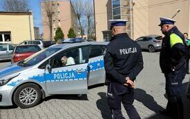 Policjanci oceniają jednego z uczni&oacute;w biorących udział w konkurencji polegajacej na znalezieniu pięciu usterek w wozie policyjnym