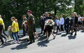 Przemarsz uczestnik&oacute;w uroczystości z kościoła na cmentarz