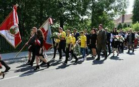 Przemarsz uczestnik&oacute;w uroczystości z kościoła na cmentarz