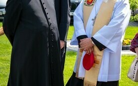 Biskup kielecki stoi na dworze z dwoma księżmi