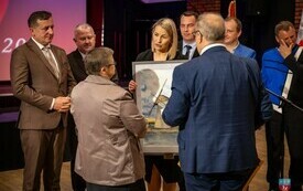 Przedstawiciele Powiatu Włoszczowskiego wręczają W&oacute;jtowi Gminy Krasocin obraz krasocińskiego wiatraka