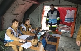 Wewnątrz namiotu strażackiego siedzi zesp&oacute;ł nadzorujący ćwiczenia