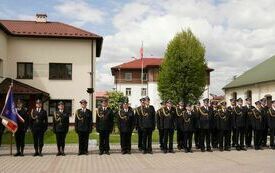 Włoszczowscy strażacy stoją w dwuszeregu przed budynkiem Urzędu Gminy Krasocin